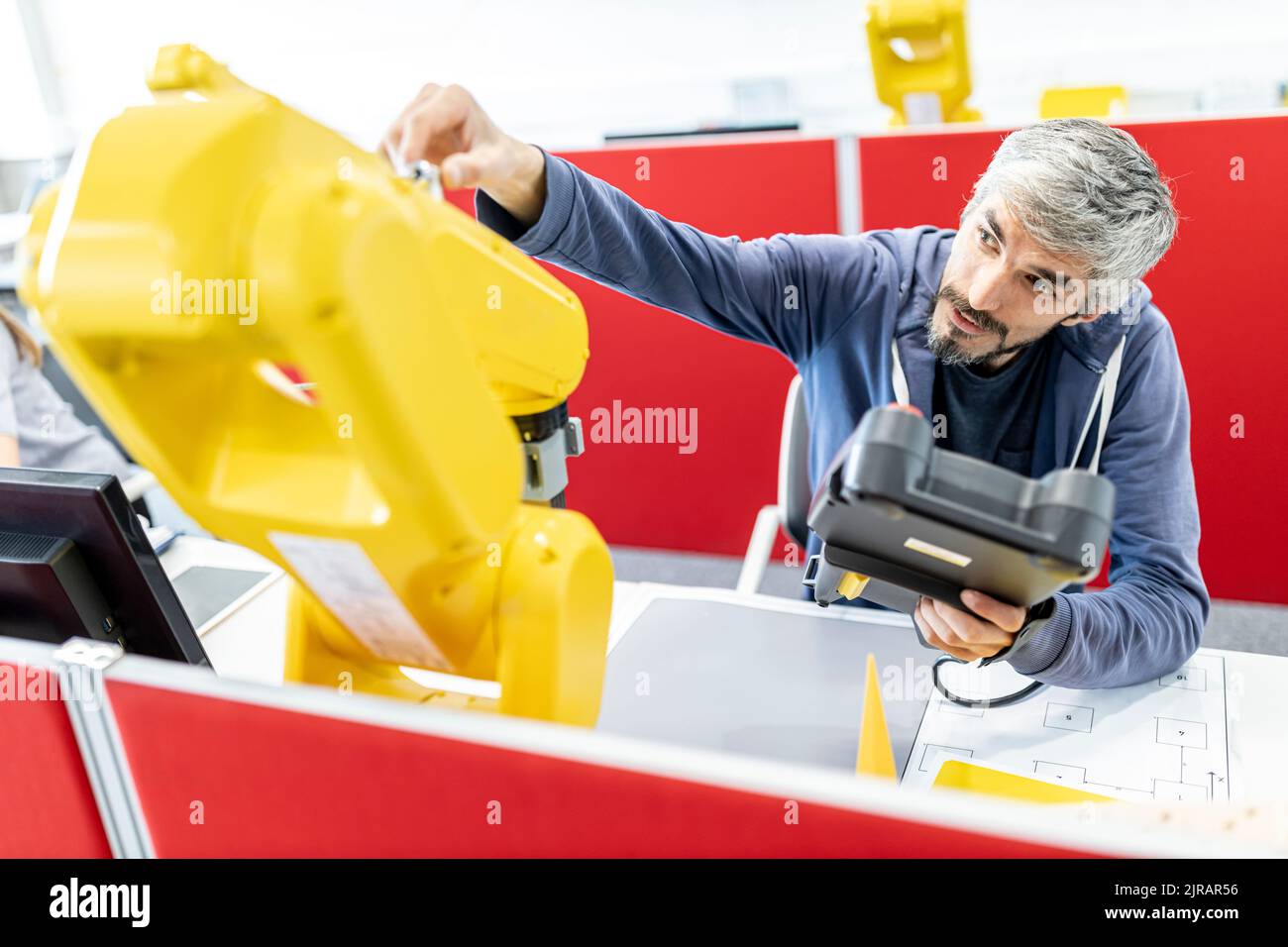 Industrial engineer working at industrial robot using digital control