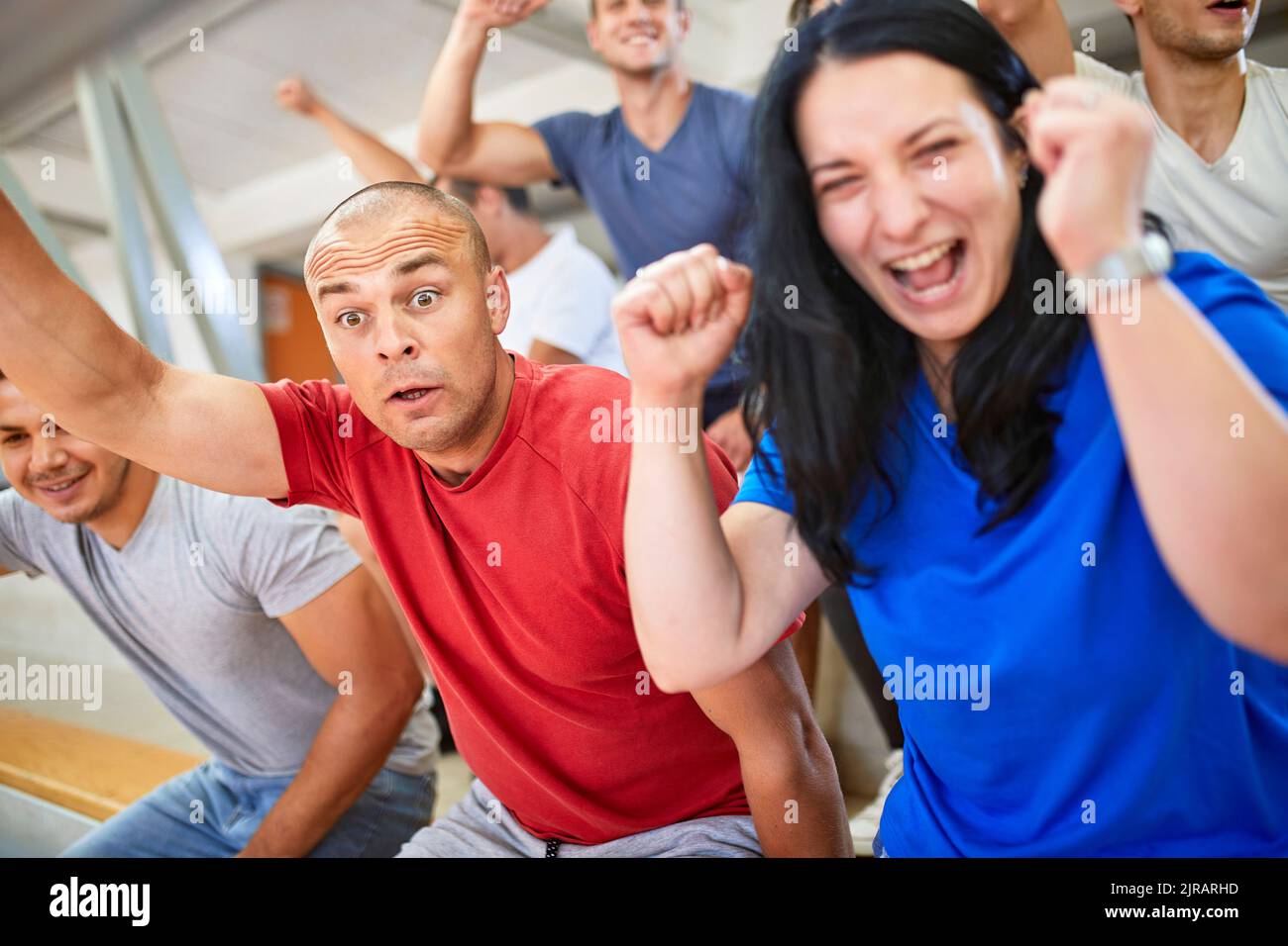 Excited fans cheering together in stadium Stock Photo