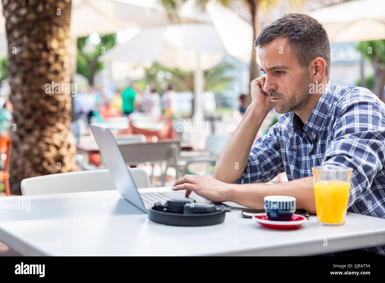 Mature freelancer using laptop sitting at cafe Stock Photo