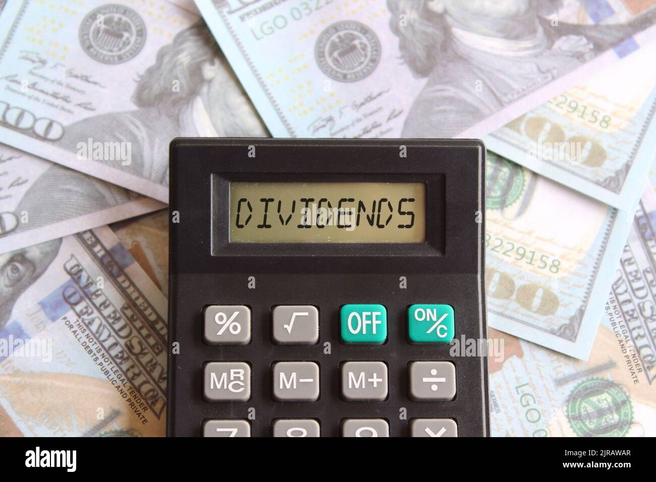 Top view image of calculator with text DIVIDENDS and money. Business and finance concept Stock Photo