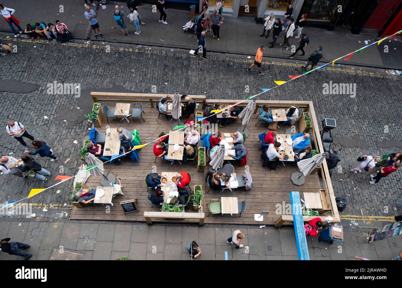 Edinburgh, Scotland, UK. 23rd  August 2022. Rubbish is seen piled on the streets of Edinburgh city centre on day six of a 12 day strike by city refuse collectors. Pic[ Outdoor diners on Victoria Street don’t seem to mind the rubbish strewn street. Iain Masterton/Alamy Live News Stock Photo