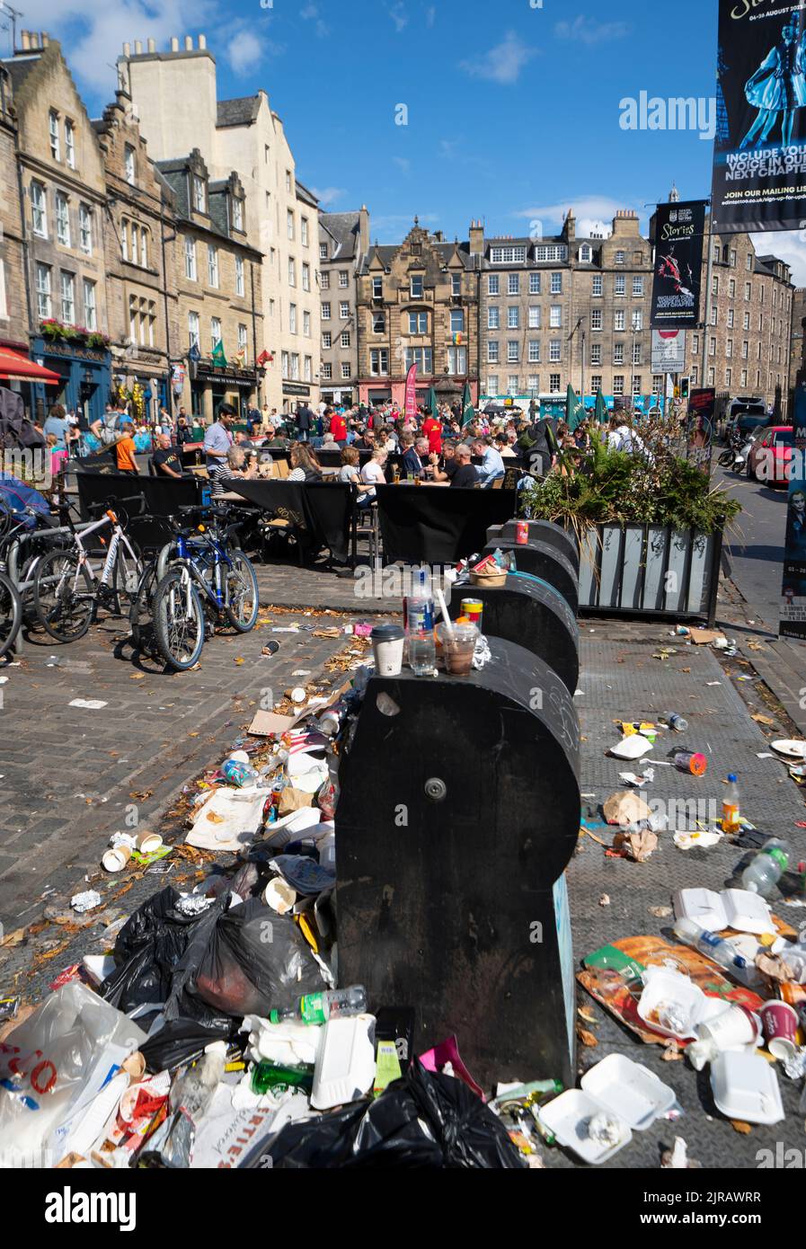 Edinburgh, Scotland, UK. 23rd  August 2022. Rubbish is seen piled on the streets of Edinburgh city centre on day six of a 12 day strike by city refuse collectors. Pic; Outdoor eating areas next to overflowing rubbish bins in the Grassmarket.  Iain Masterton/Alamy Live News Stock Photo