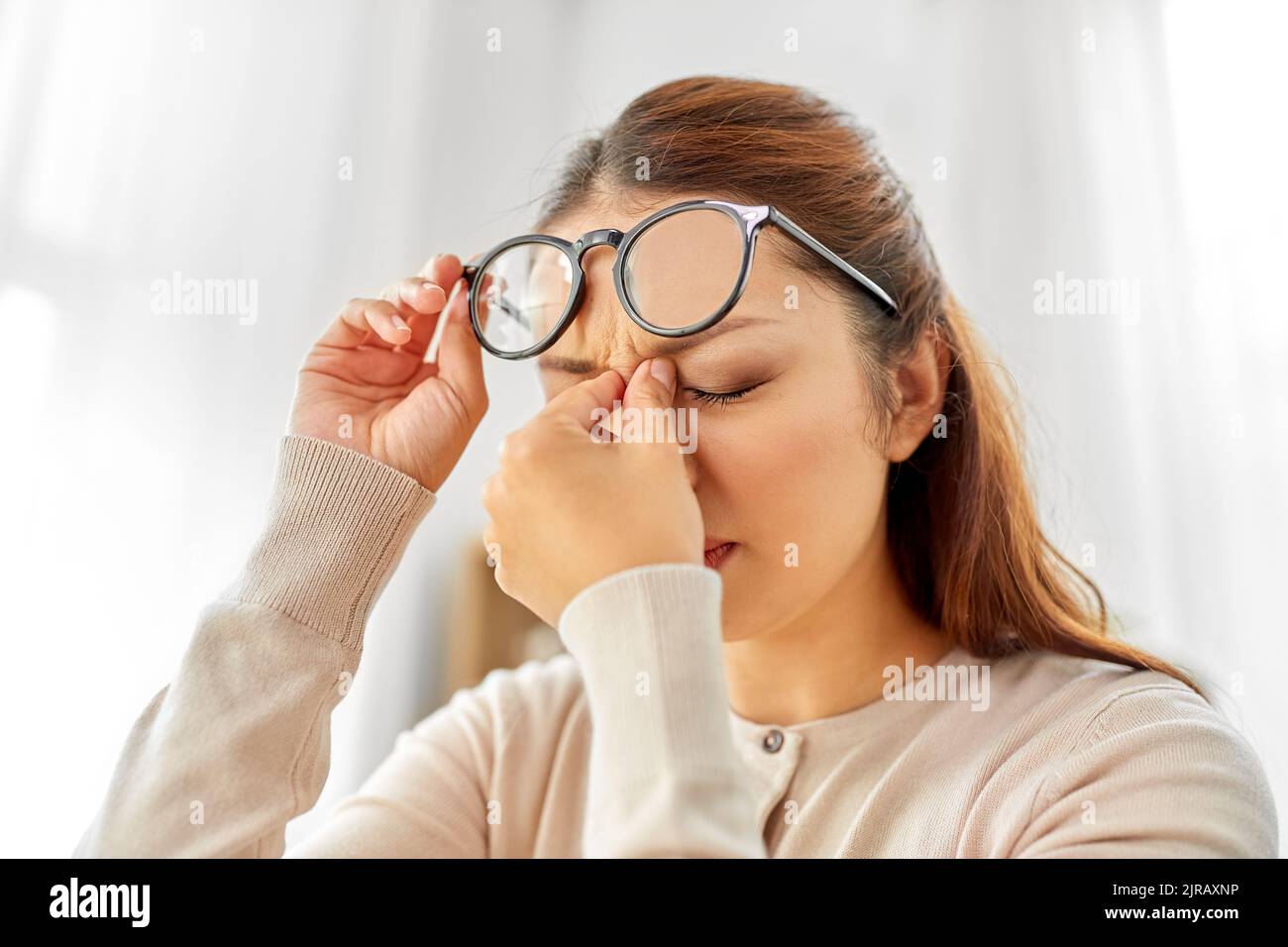 tired asian woman with glasses rubbing nose bridge Stock Photo Alamy
