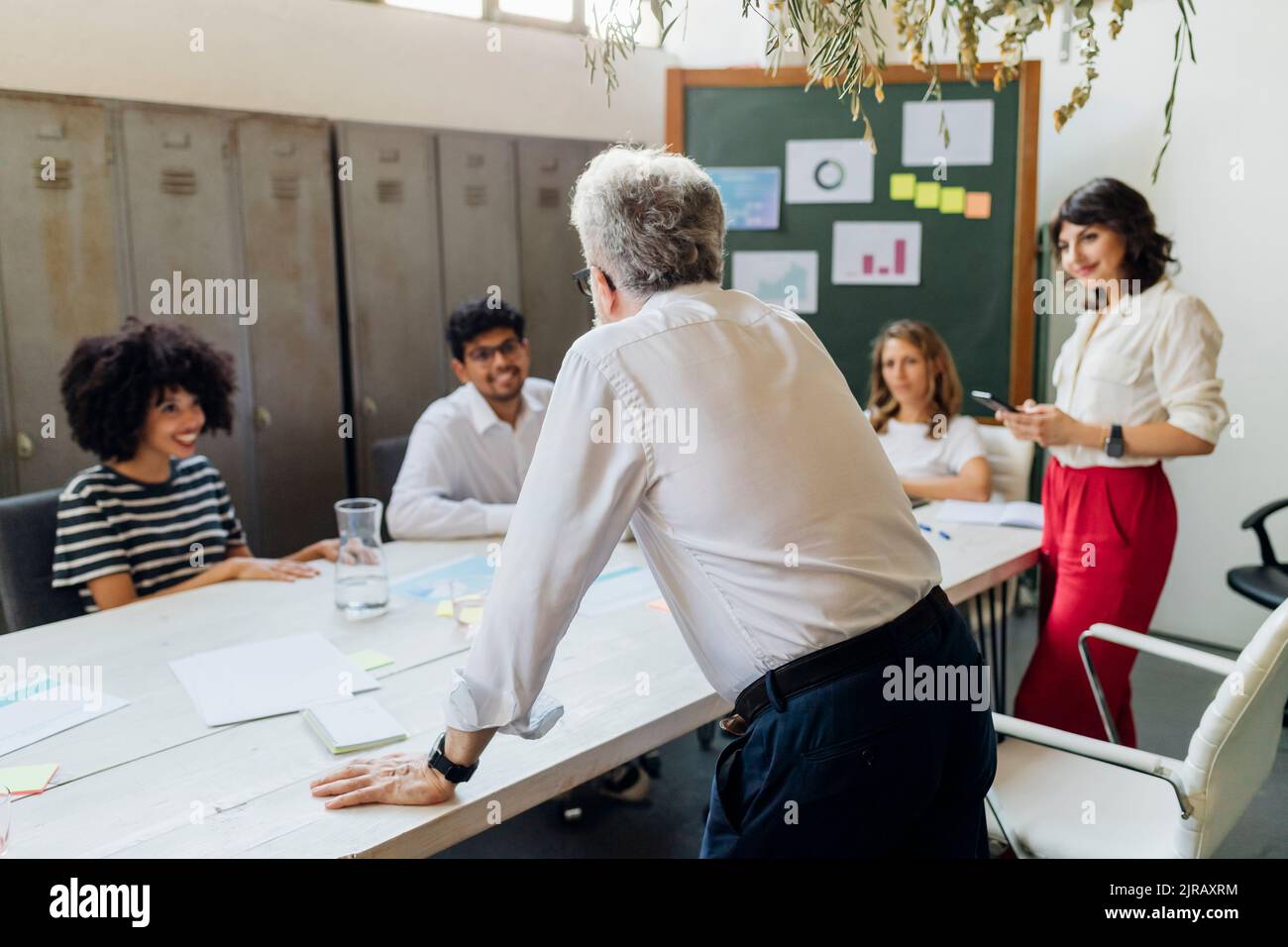 Senior businessman conducting meeting with coworkers at office Stock Photo