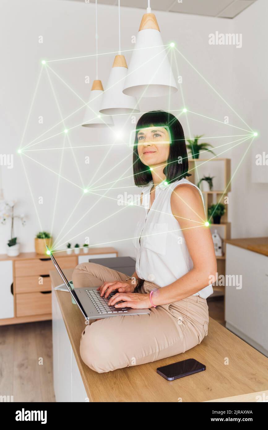 Woman at home working remotely using laptop in cyberspace Stock Photo