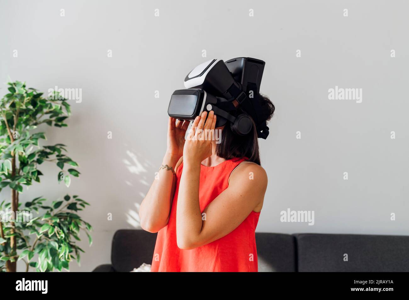Woman wearing virtual reality simulator at home Stock Photo - Alamy