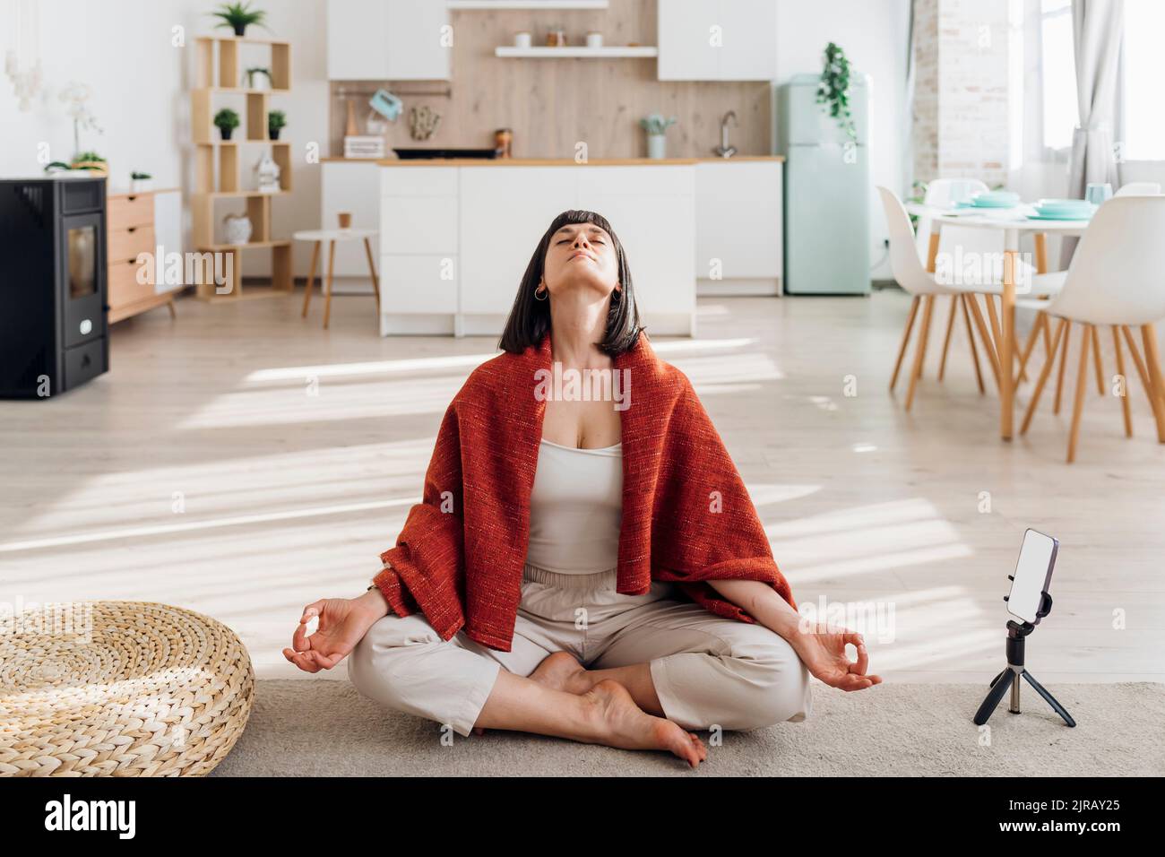 Woman sitting crosslegged doing meditation at home Stock Photo Alamy