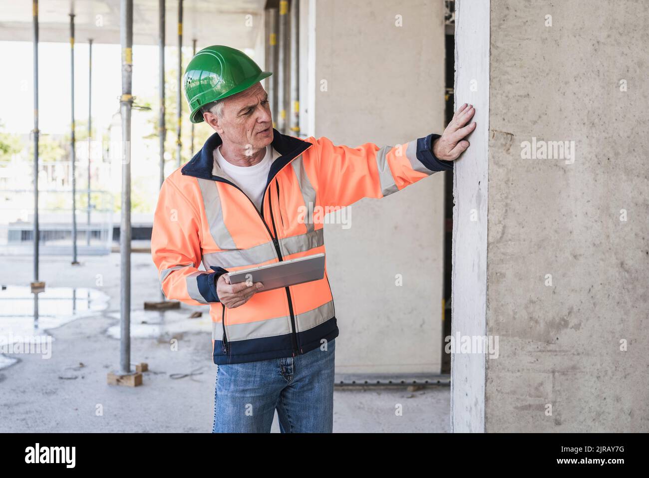 Senior contractor with tablet PC examining column Stock Photo