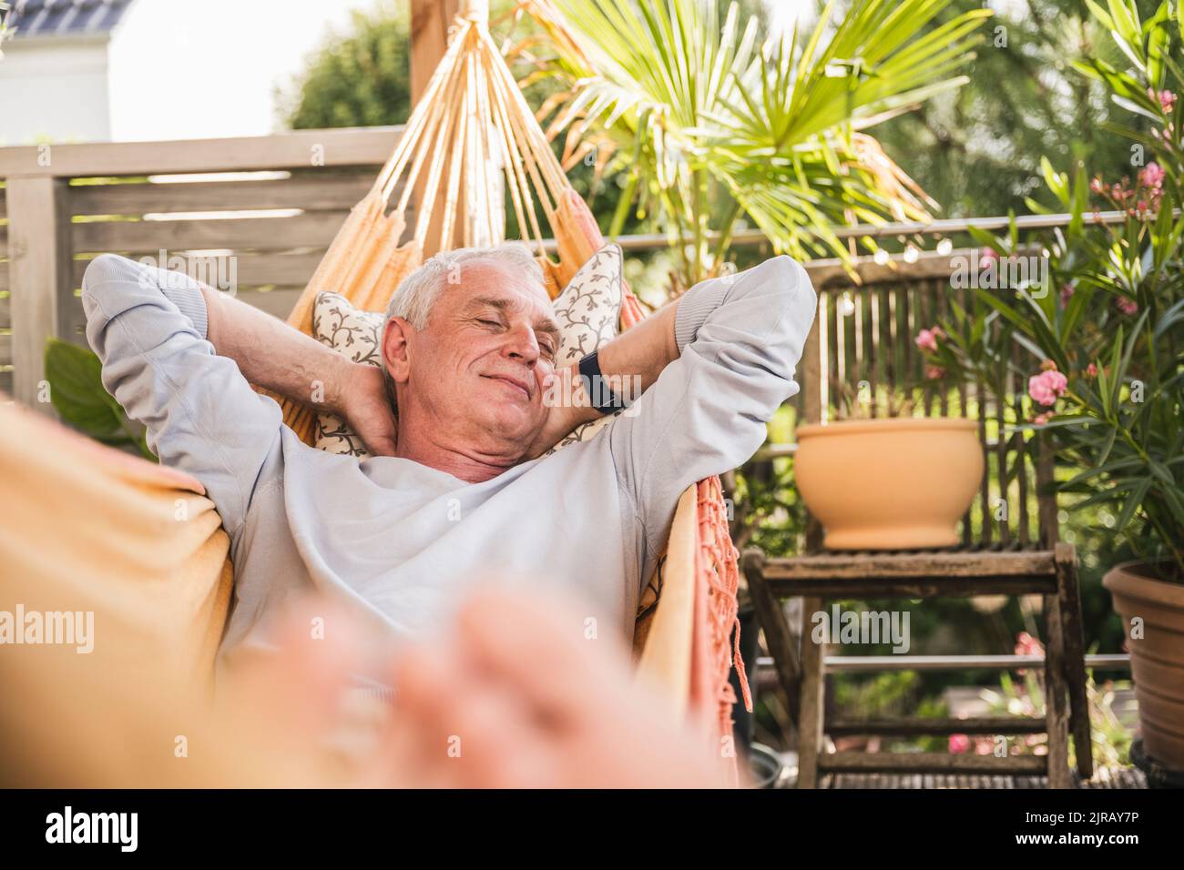 Senior man napping in hammock Stock Photo
