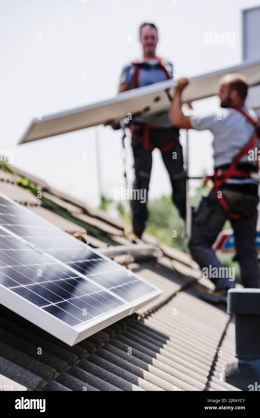 Electricians installing solar panels on house roof Stock Photo Alamy