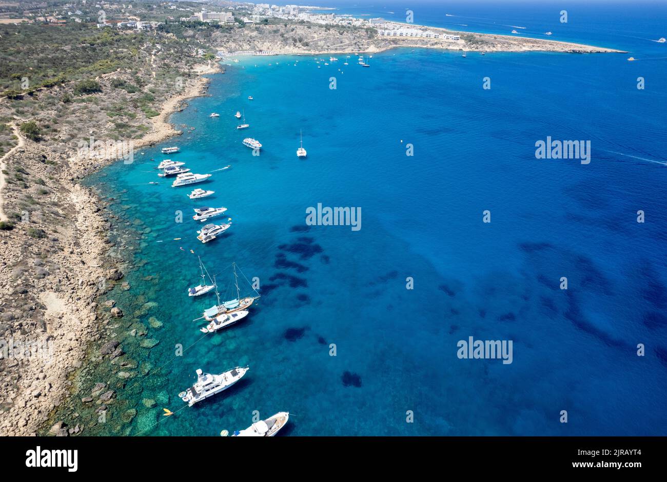 Drone aerial seascape luxury yachts moored in the coast unrecognised people swimming and relaxing. Summer vacations in the sea. Ayia Napa Cyprus Stock Photo