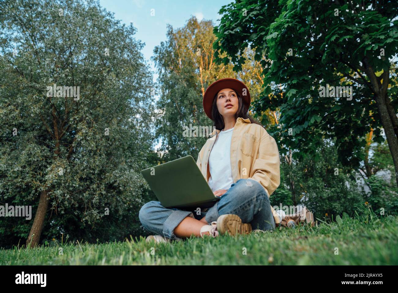 Thoughtful freelancer with laptop in park Stock Photo