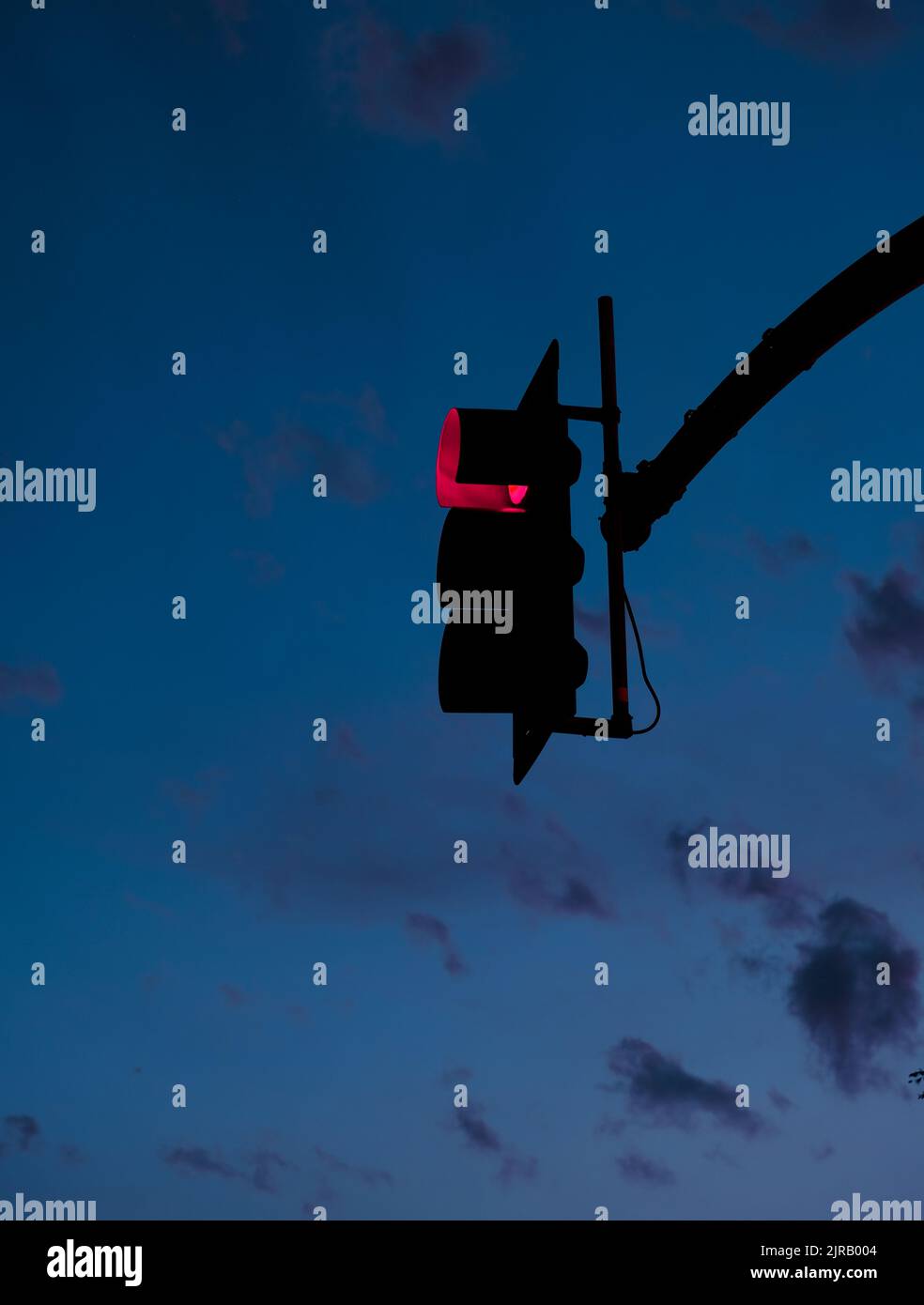 Glowing traffic light at night with sky and clouds in background Stock