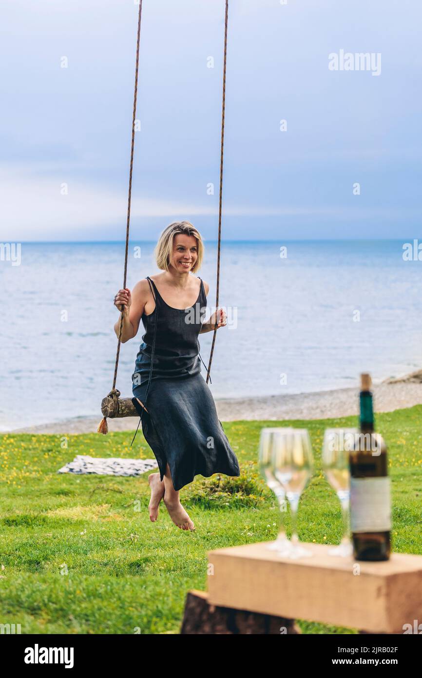 Mature woman sitting on swing hi-res stock photography and images - Alamy