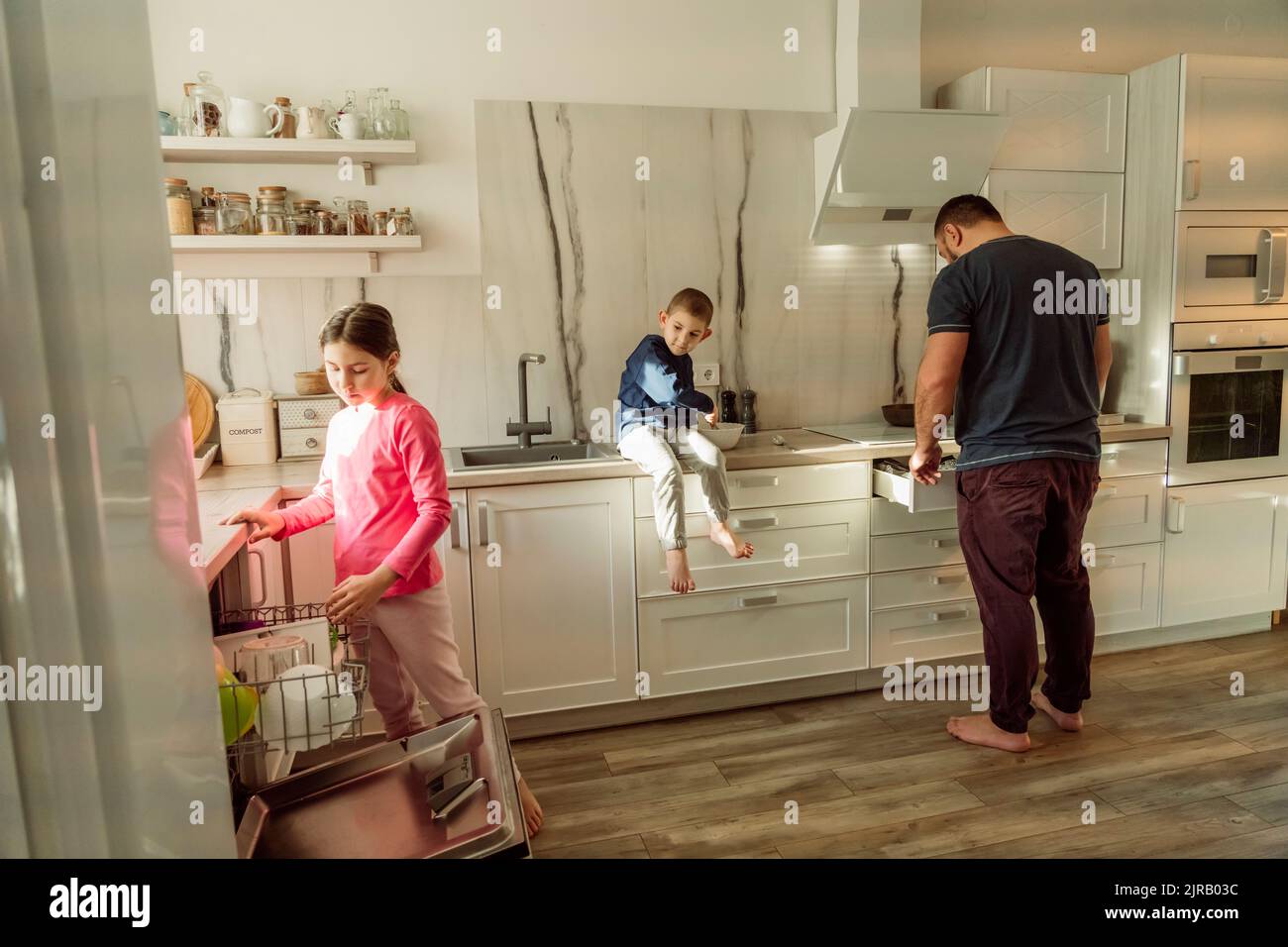 Father with children in kitchen at home Stock Photo