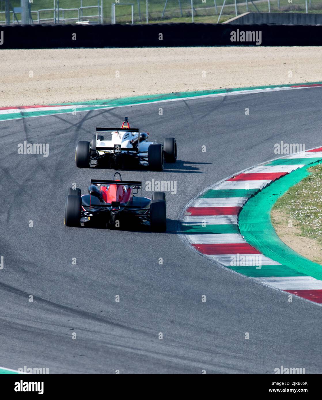 Rear view of asphalt racetrack turn and curbs with formula cars racing motor sport. Mugello, Italy, march 25 2022. 24 Hours series Stock Photo