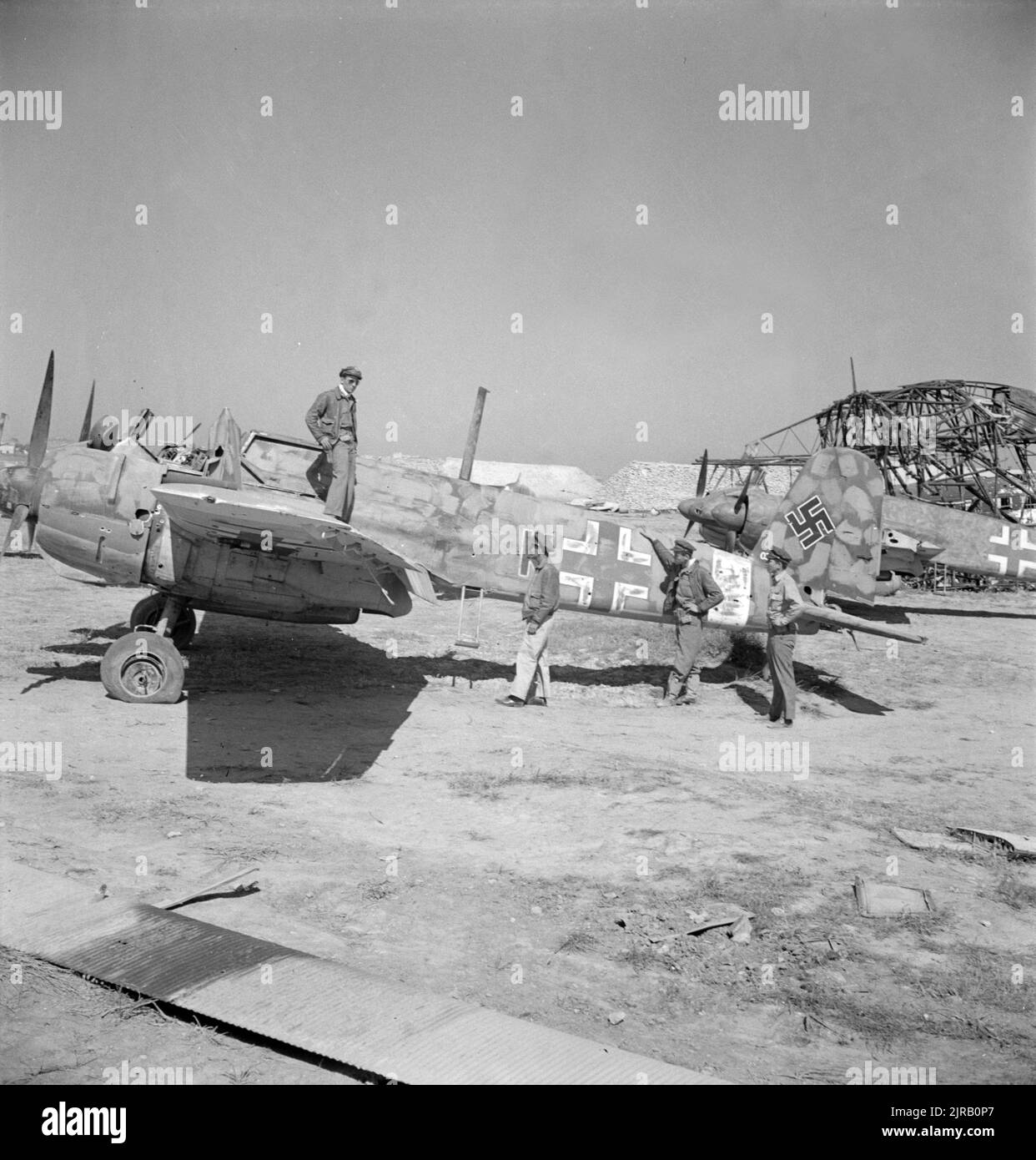 A vintage photo circa May 1943 showing American pilots inspecting a wrecked German Henschel Hs 129 tank busting and ground attack aircraft at El Aouiana Tunisia after the defeat of the Axis forces in North Africa in World War Two Stock Photo
