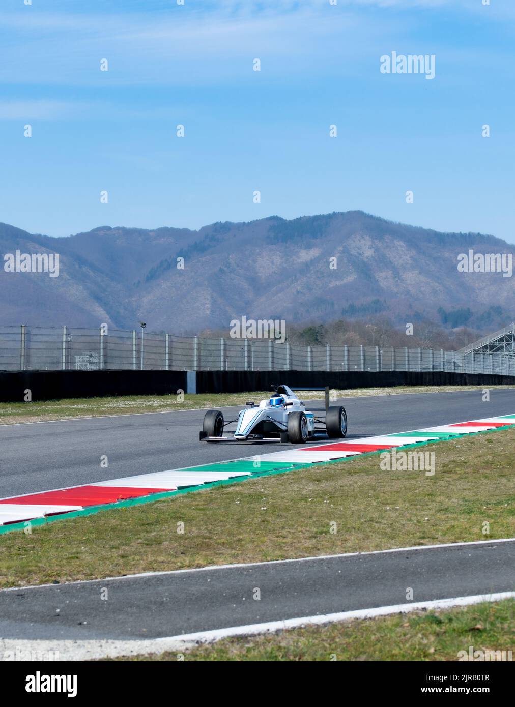Racetrack landscape view with mountains panoramic background and car racing on track. Mugello, Italy, march 25 2022. 24 Hours series Stock Photo