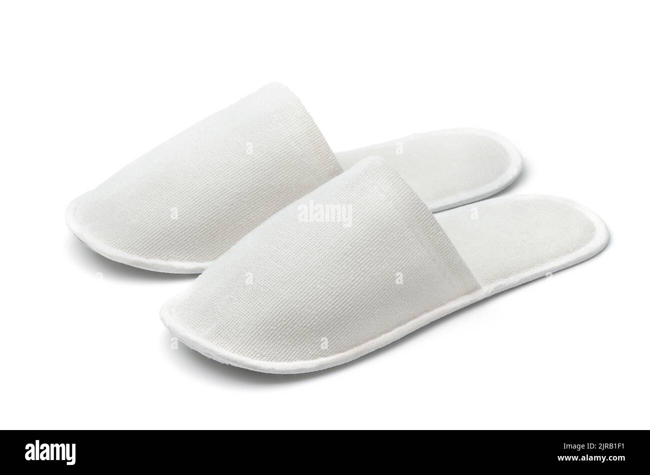 Pair of white disposable textile slippers isolated on white Stock Photo