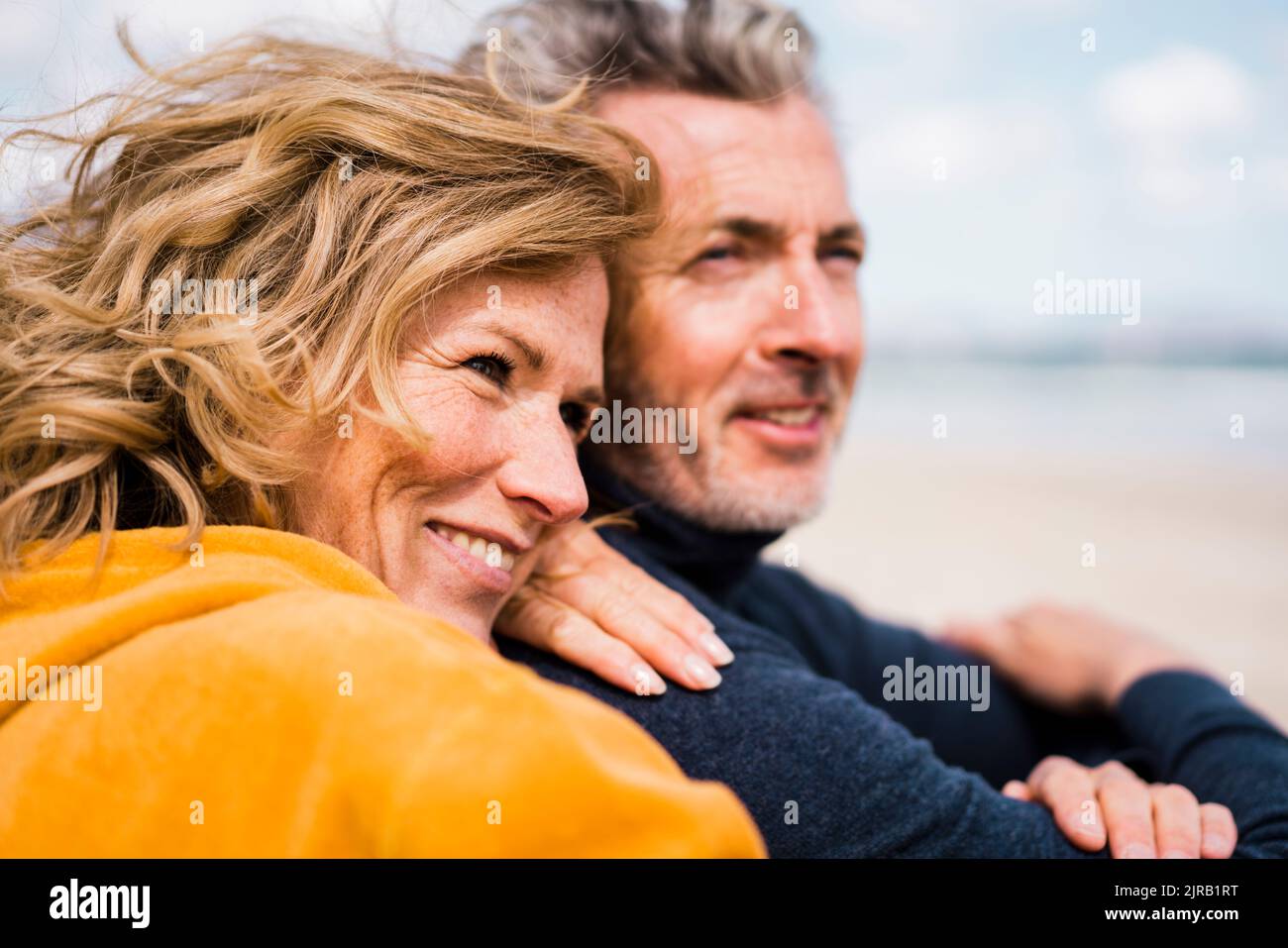 Happy mature woman with man enjoying vacation at beach Stock Photo