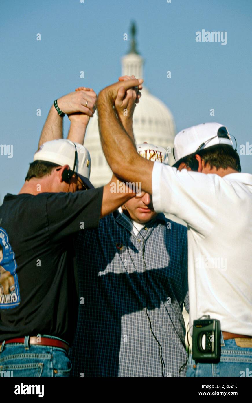 Members of the Promise Keepers, a conservative Christian organization, pray during a service on the National Mall, October 4, 1997 in Washington, DC. An estimated 700,000 men gathered for the 'Stand in the Gap: A Sacred Assembly of Men' prayer event. Stock Photo