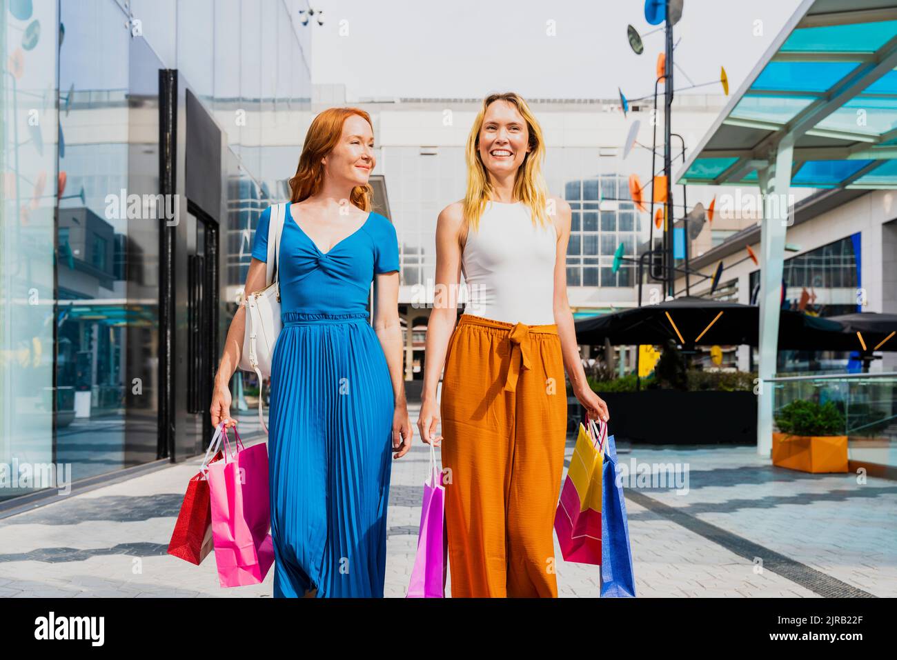 Women walking away carrying shopping bags hi-res stock photography and ...