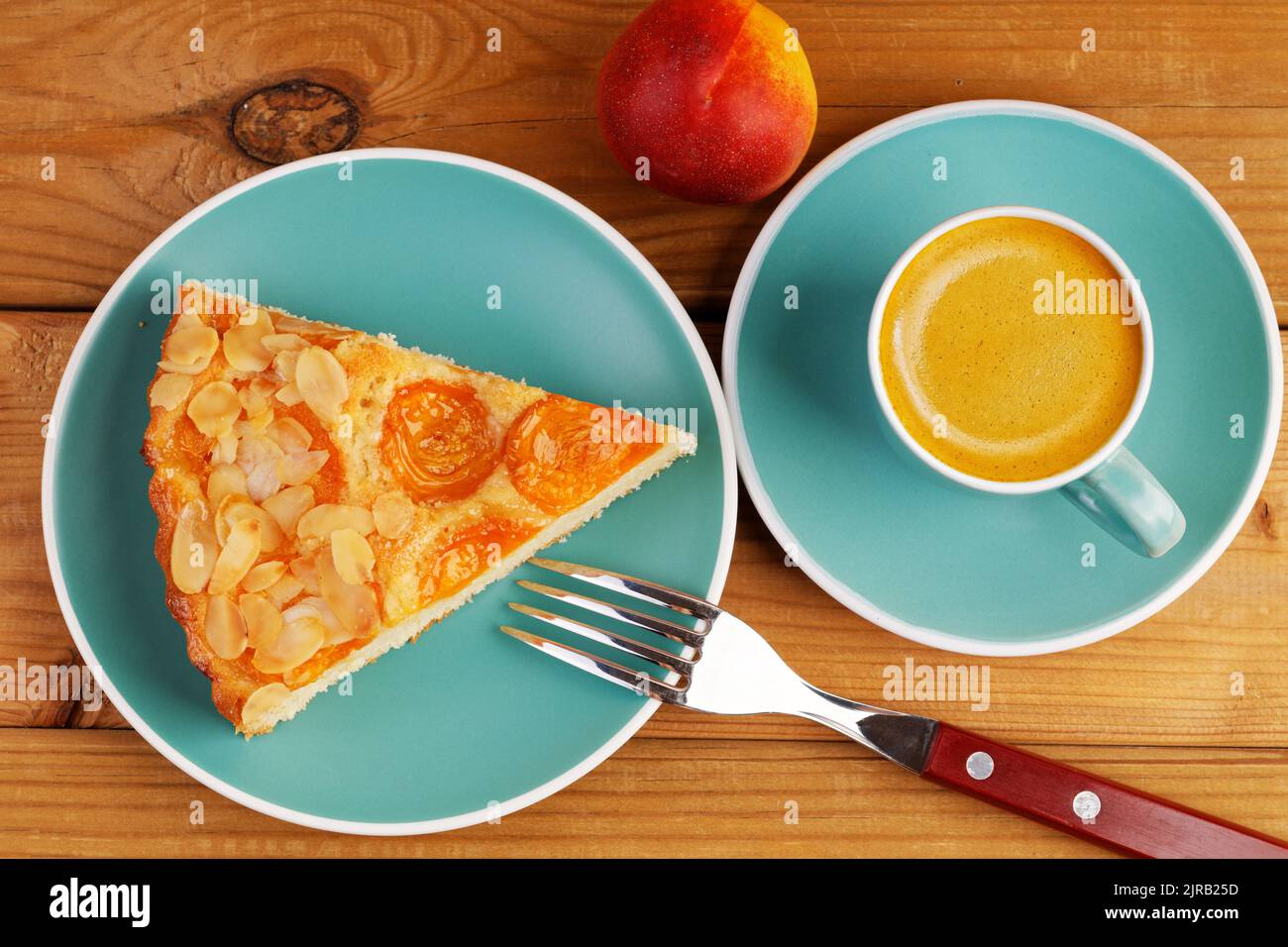 Closeup piece of homemade pie with apricots and cup of coffee espresso on wooden table. Top view. Stock Photo