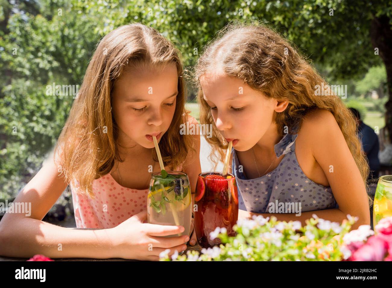 Girl with sister drinking fruit lemonades Stock Photo