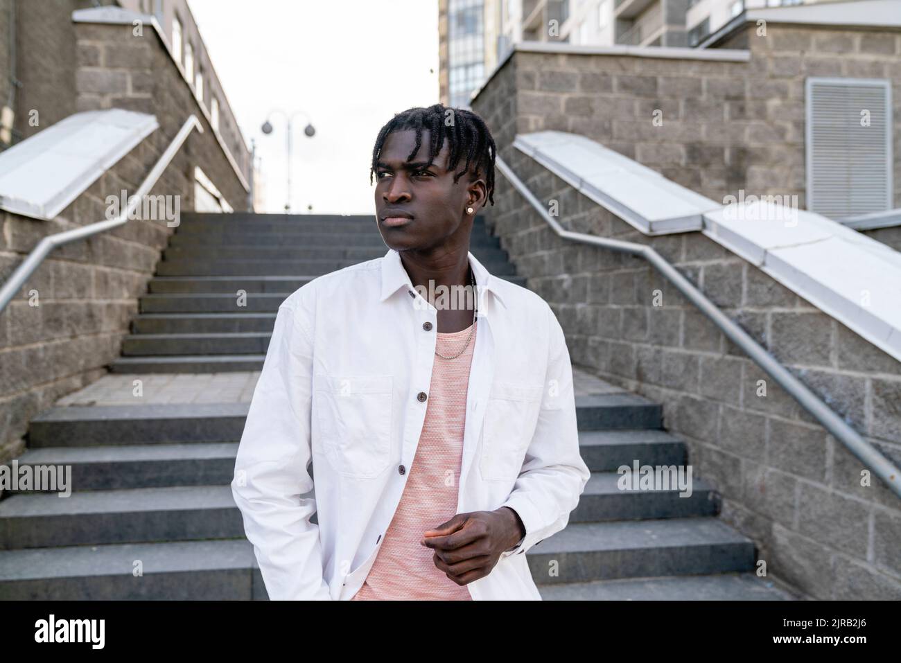Thoughtful man standing in front of steps Stock Photo
