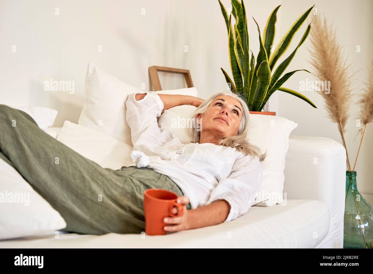Casual woman lying on sofa hi-res stock photography and images - Alamy