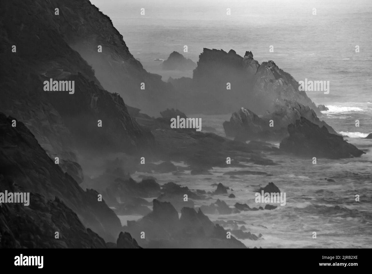 Hazy, Black and white, View along the jagged, seaside cliffs of the Tsitsikamma Mountains. Stock Photo