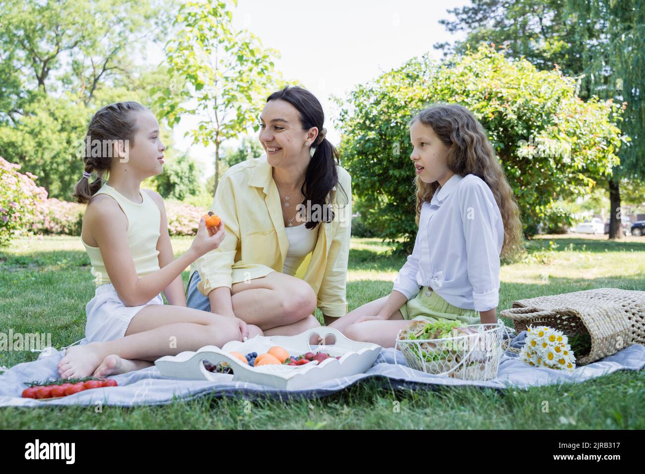 Happy daughters on picnic with mother in park Stock Photo - Alamy