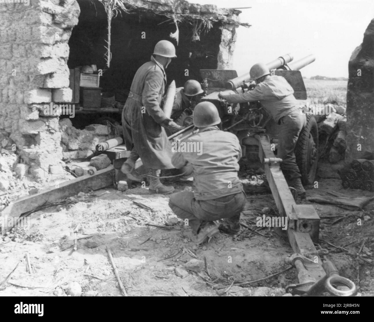 A vintage photo circa February 1943 of American soldiers manning a 105 mm howitzer, Battery B 33rd Field Artillery during fighting at the Kasserine Pass in Tunisia, North Africa Stock Photo