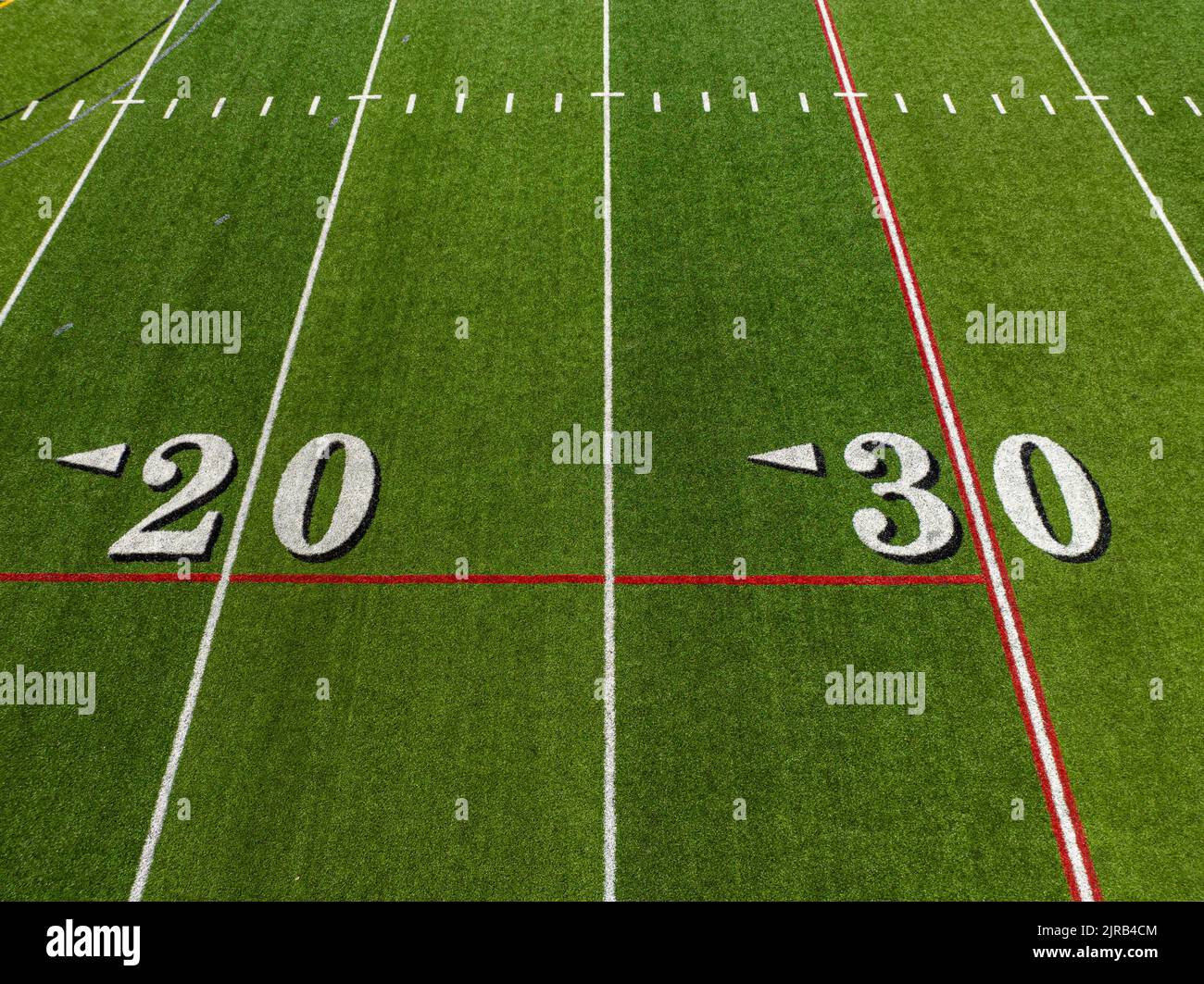 Synthetic turf football field, between the 20 and 30 yard lines in