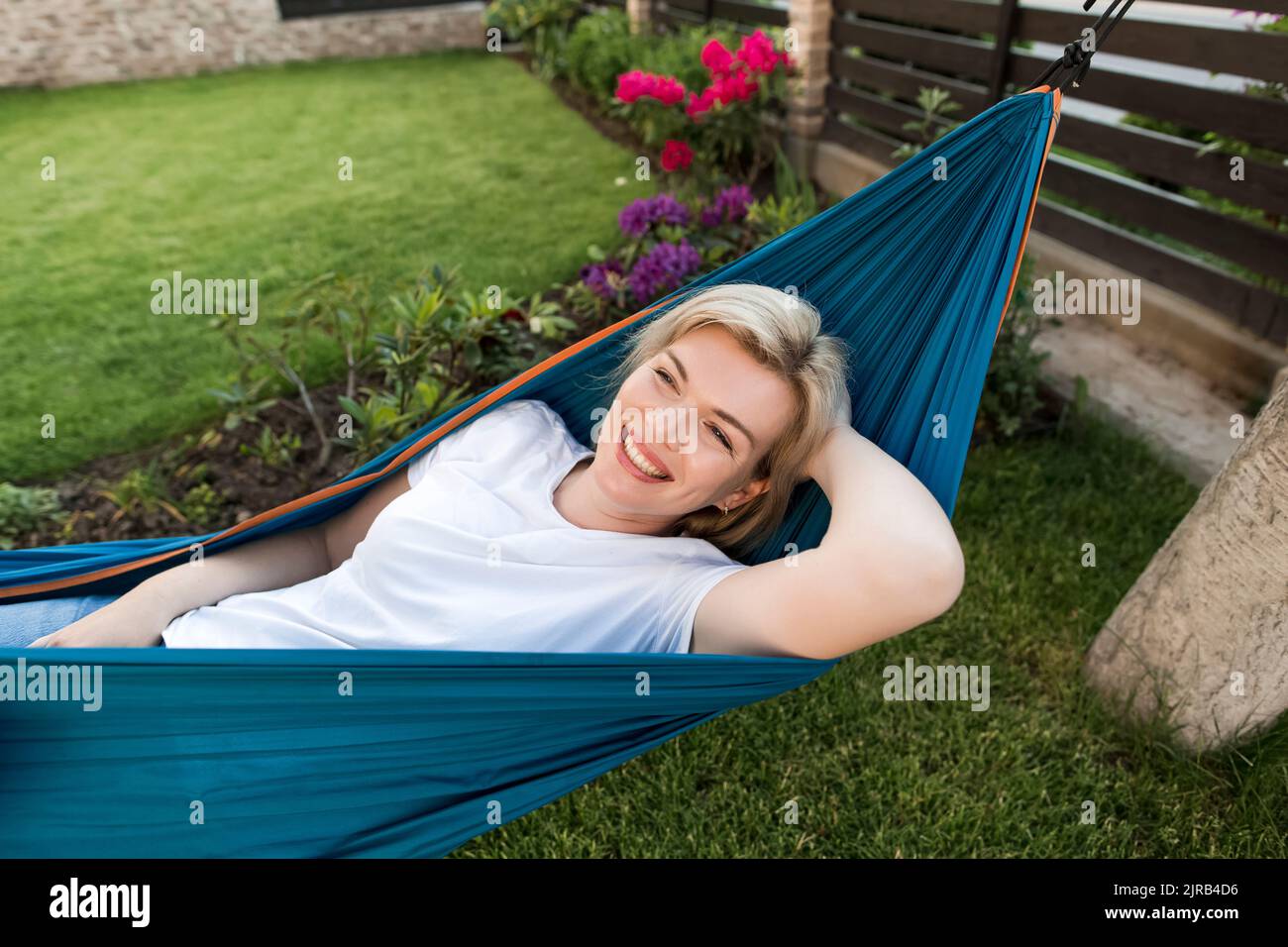 Happy mature woman lying on hammock in garden Stock Photo - Alamy