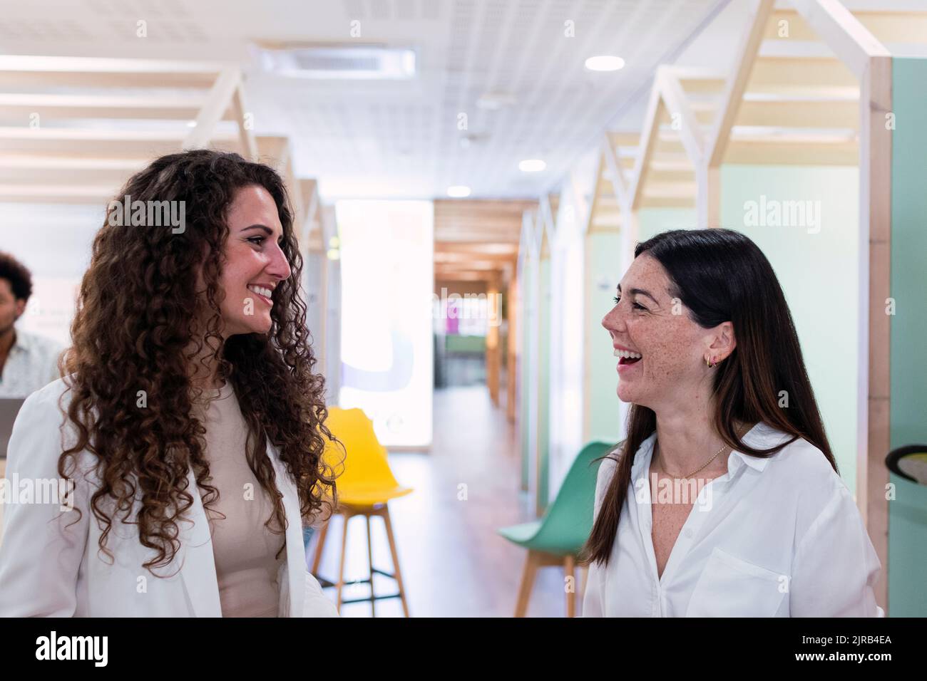 Two happy businesswomen talking in office Stock Photo