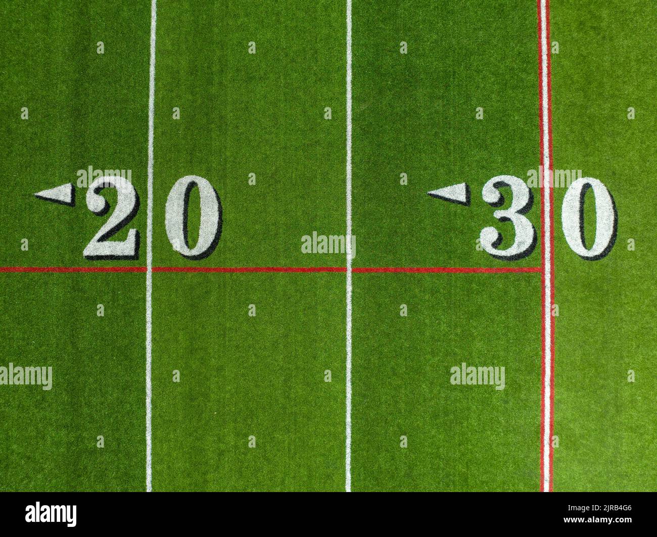 Synthetic turf football field, between the 20 and 30 yard lines in