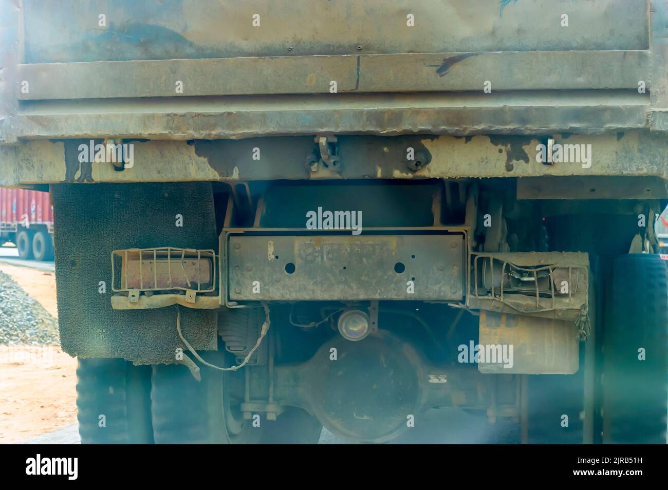 A heavy dumper truck without a license plate and with a non-functional broken taillight plying on an Indian highway. Stock Photo