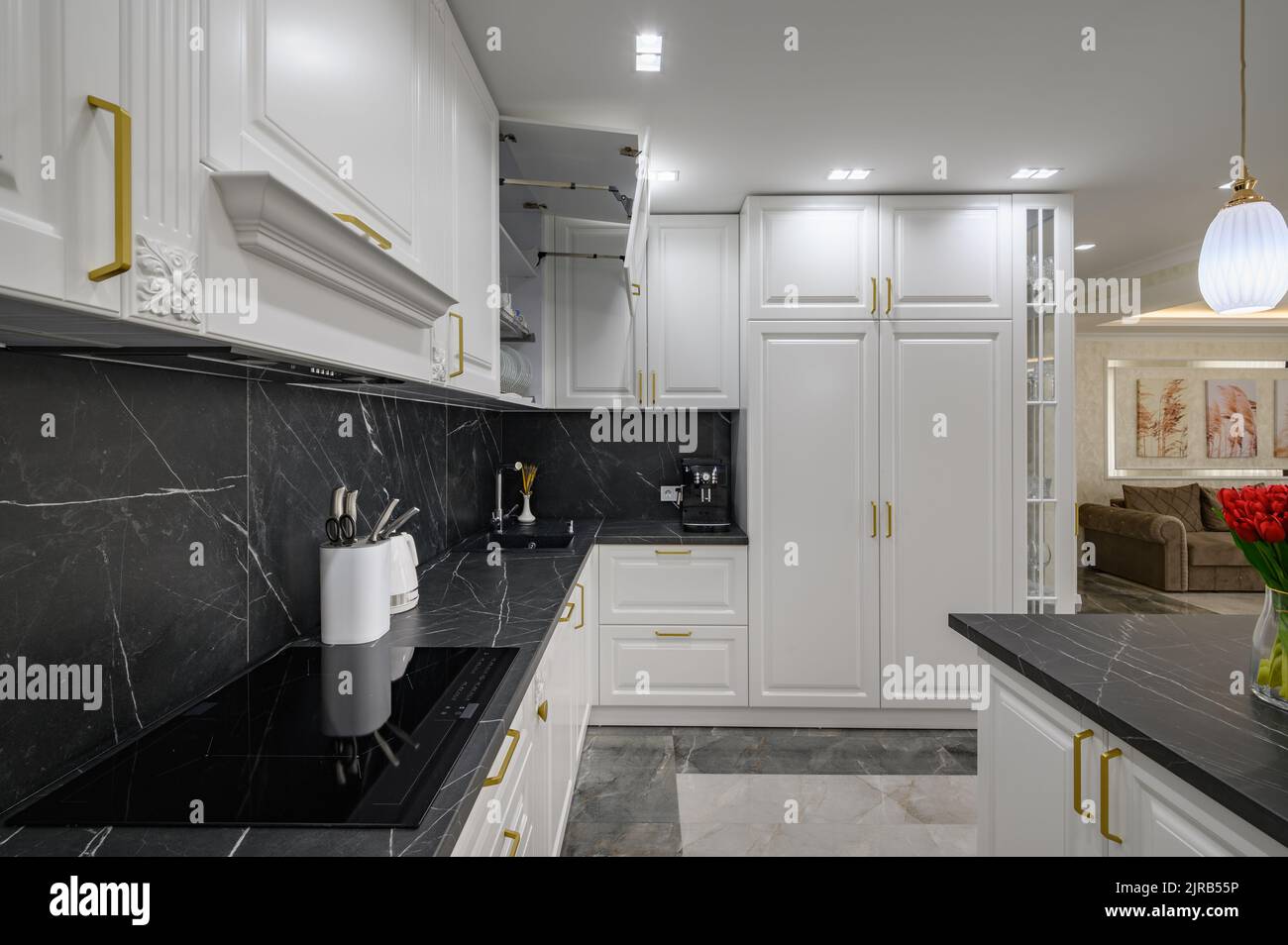 Closeup to black granite worktop of white domestic kitchen with marble