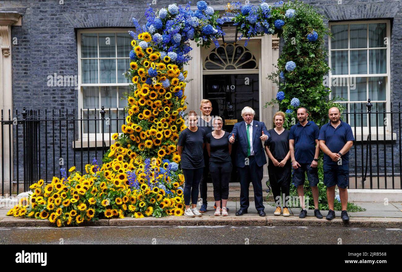 London, UK. 23rd Aug, 2022. EMBARGOED TILL 9PM ON AUGUST 23RD Boris Johnson poses with the team of Florists who created the display. Boris Johnson poses at the door of Number 10 with a floral display to commemorate Independenc day in Ukraine which is on August 24th. Credit: Mark Thomas/Alamy Live News Stock Photo