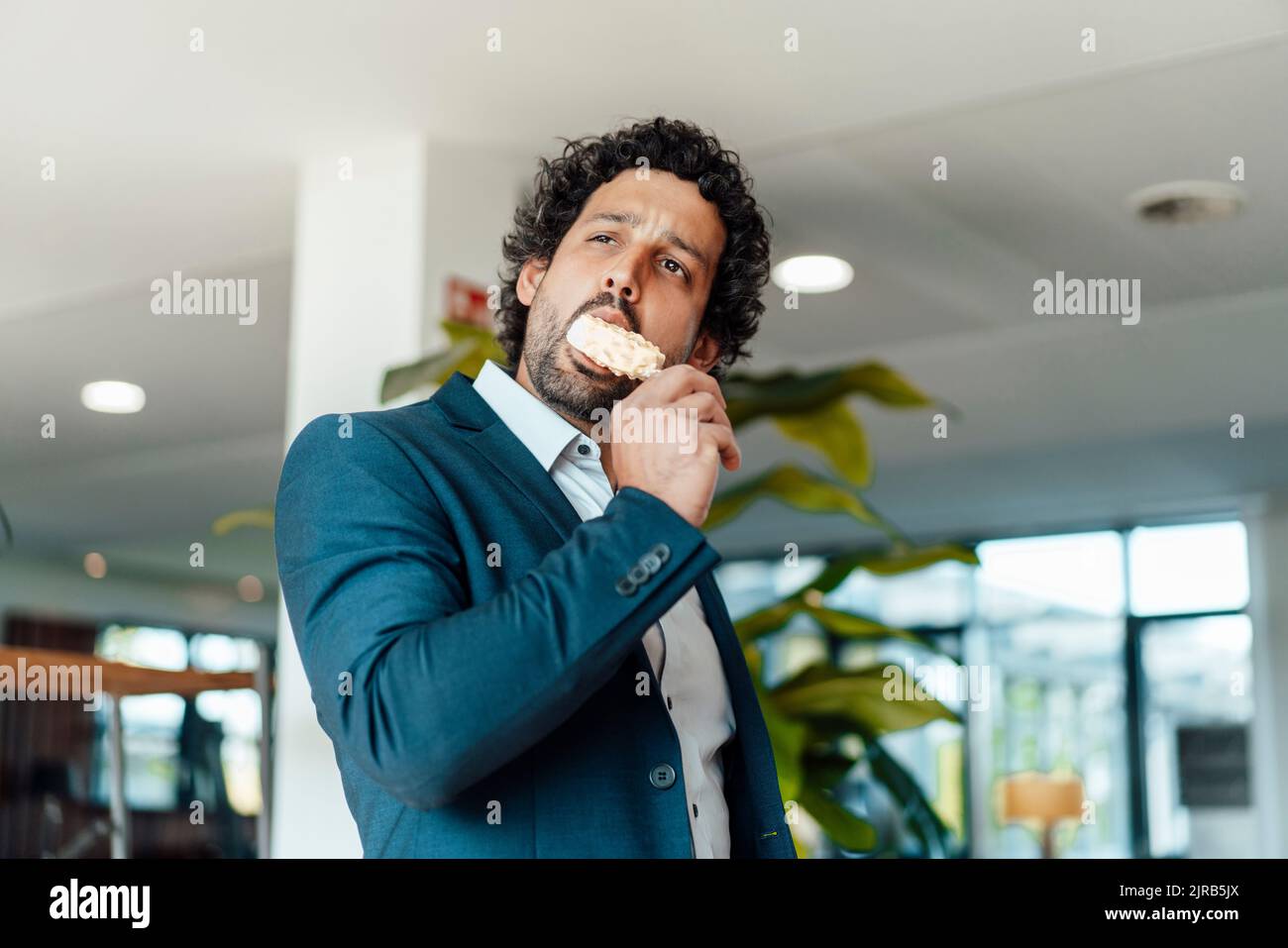 Businessman eating flavored ice cream in office Stock Photo