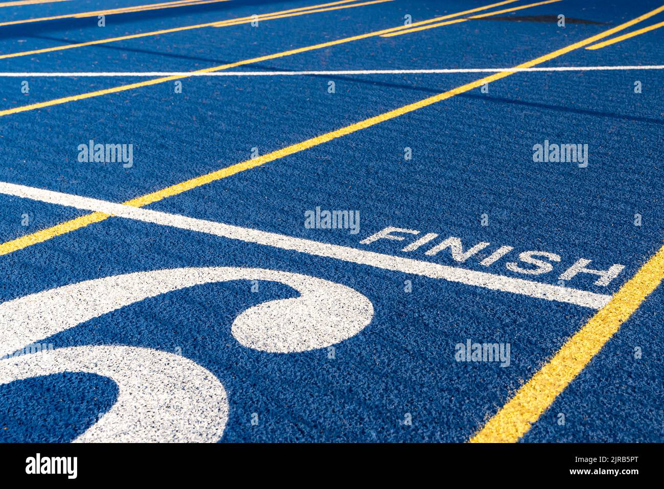 Close up of the finish line on new blue running track with yellow lane