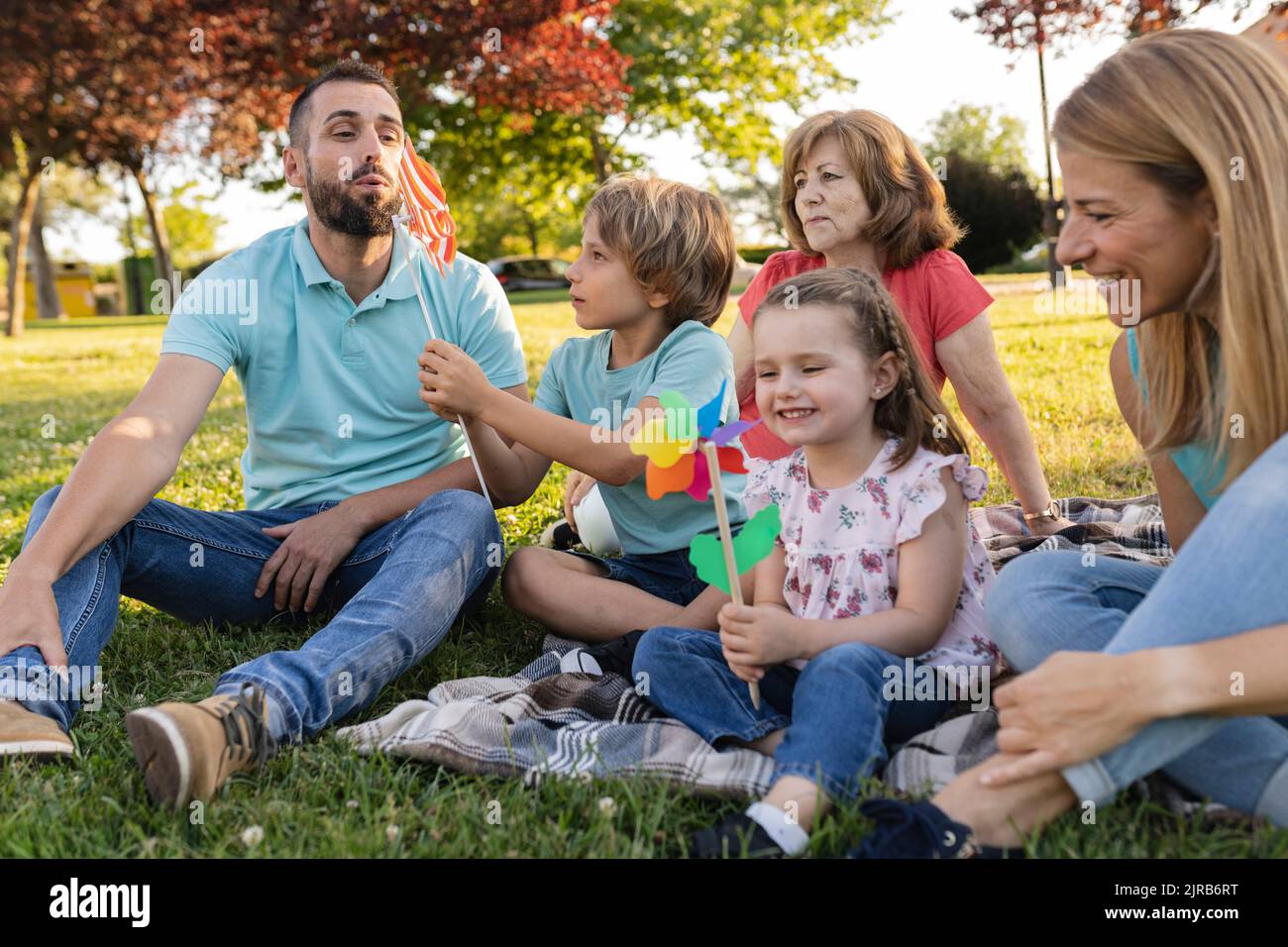 Happy family playing with pinwheels at park Stock Photo