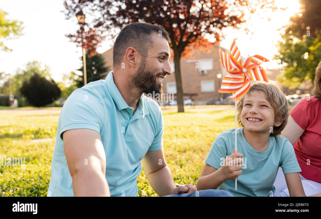 Happy father and son playing with pinwheel at park Stock Photo - Alamy