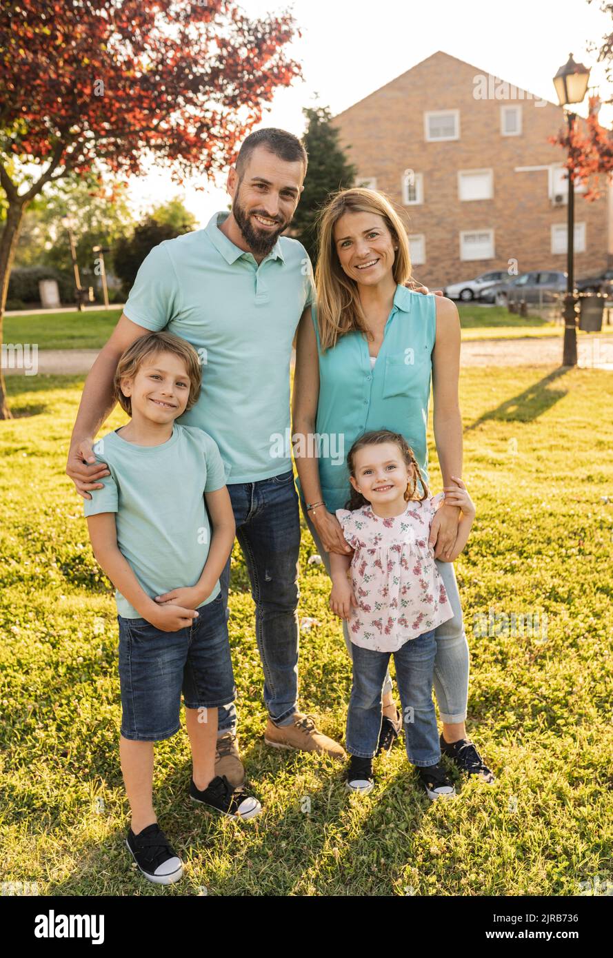 Parents standing with son and daughter at park Stock Photo