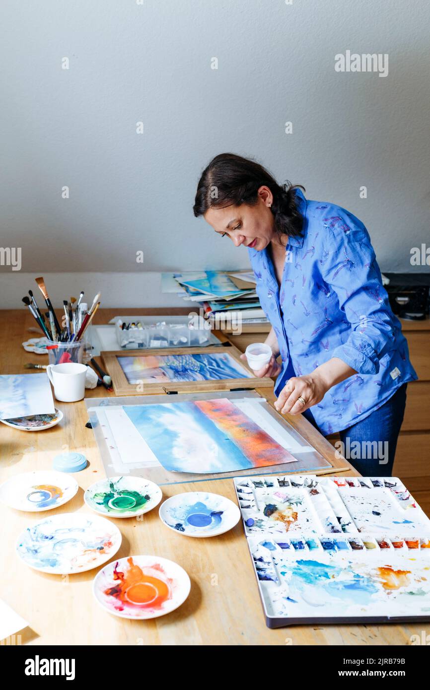 Artist sprinkling salt on watercolor painting at home stock photo alamy