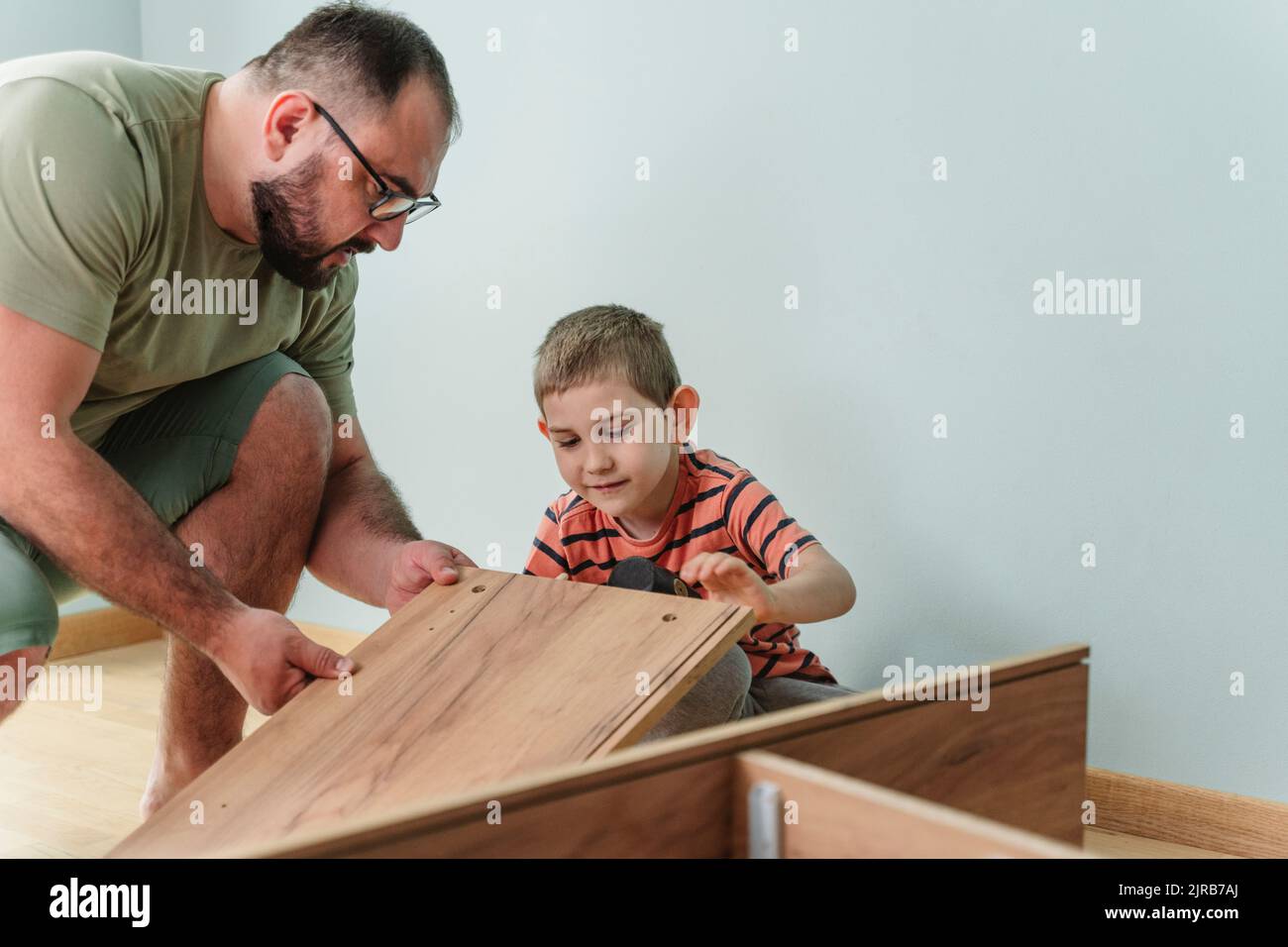 Father and son installing furniture at home Stock Photo Alamy