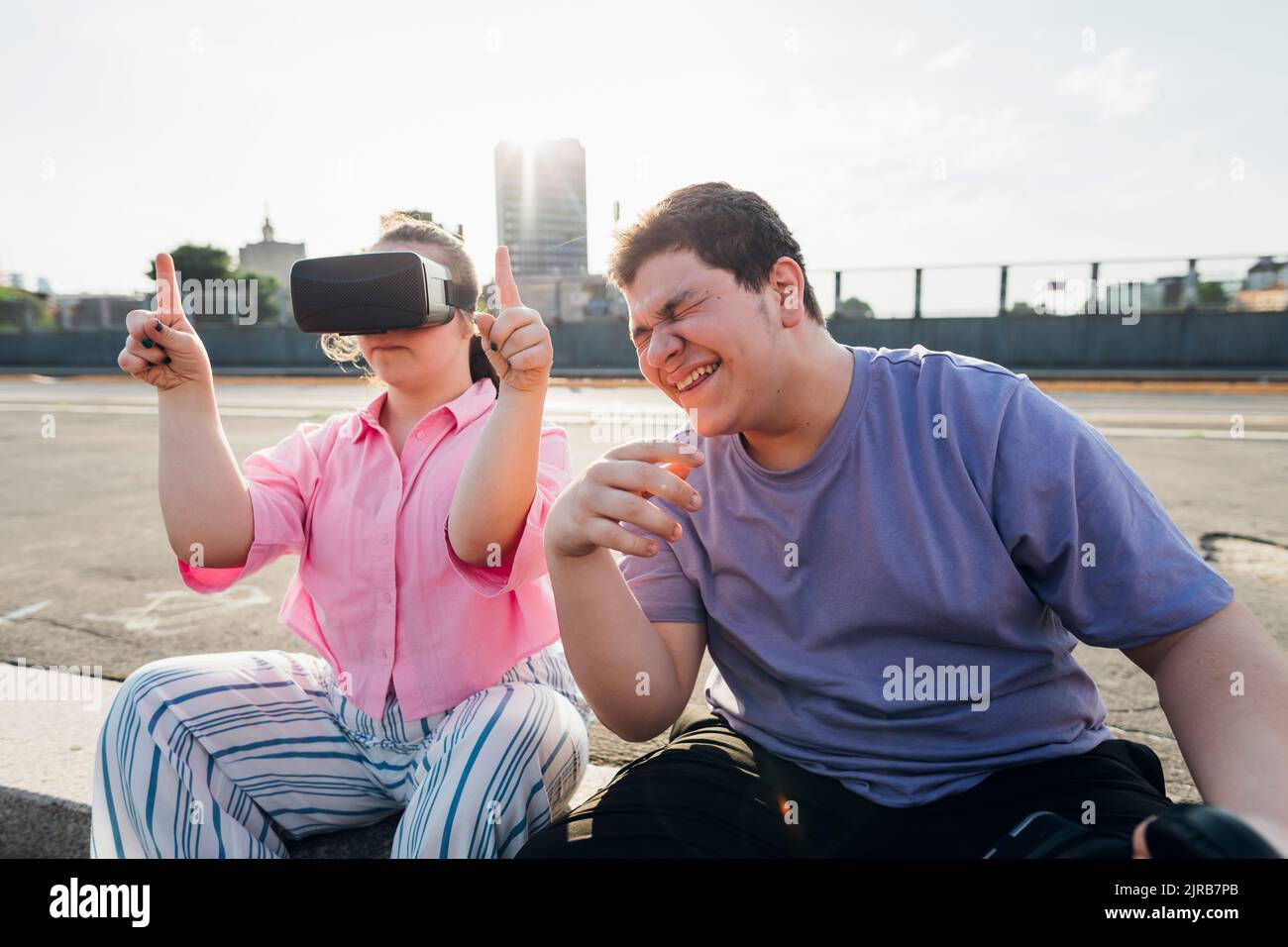 Brother laughing by sister with down syndrome wearing virtual reality ...