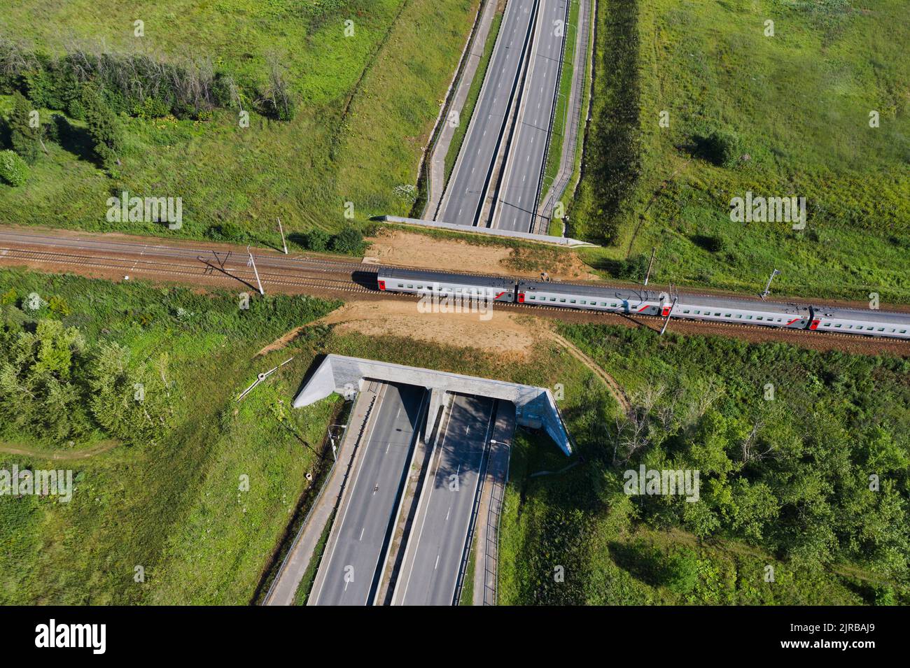 Aerial view of passenger train passing across railroad overpass Stock Photo