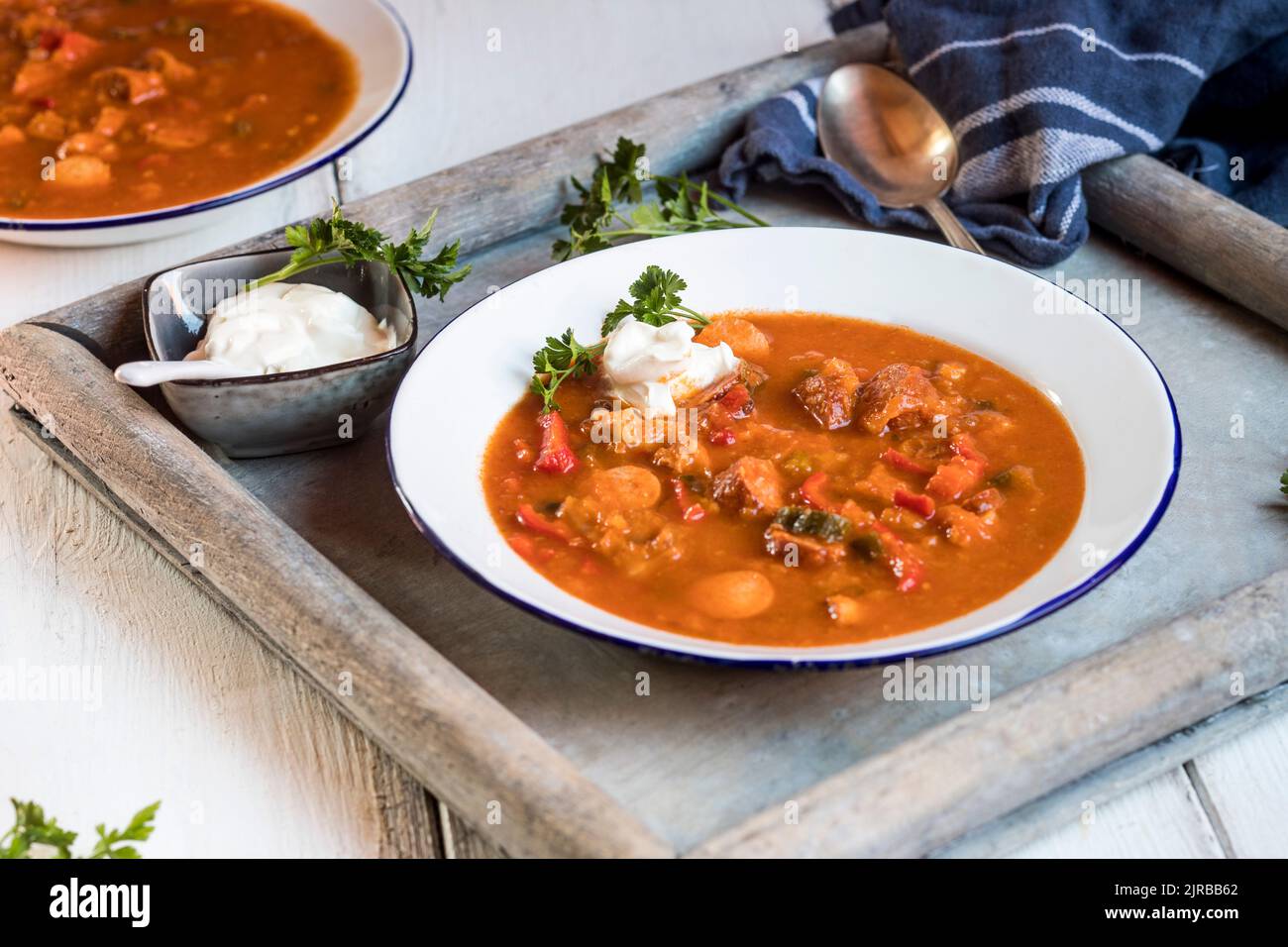 Bowl of ready-to-eat solyanka soup with sour cream and parsley Stock Photo